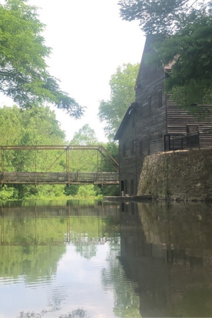 Looking at Pine Mill Bridge and the restored historic Pine Creek Grist Mill over the water of Pine Creek at Wildcat Den State Park